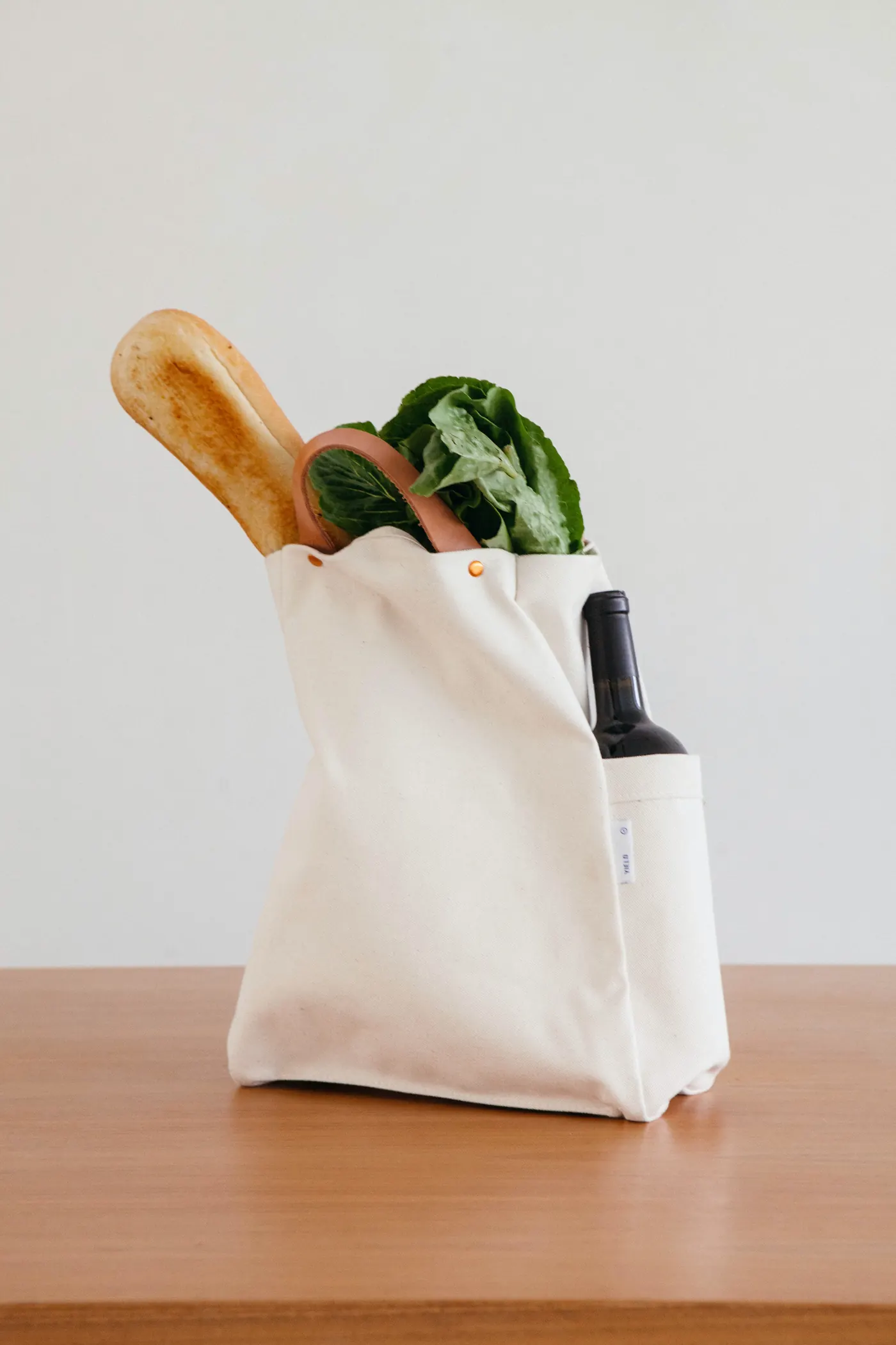 Canvas tote bag holding fresh bread and greens