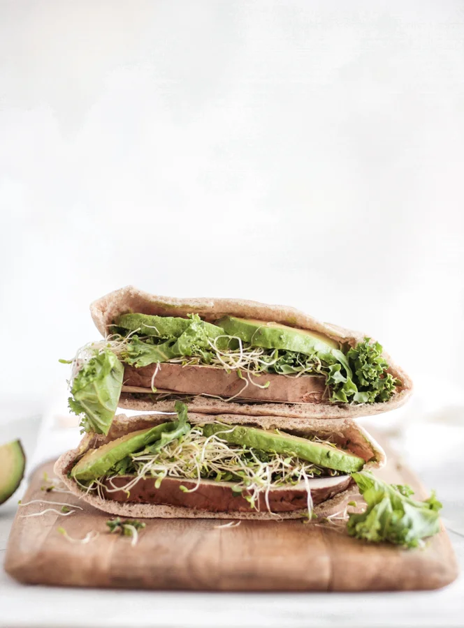 Pita sandwiches stacked with sprouts and greens